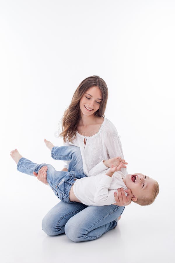 Cheerful young woman is playing with her child