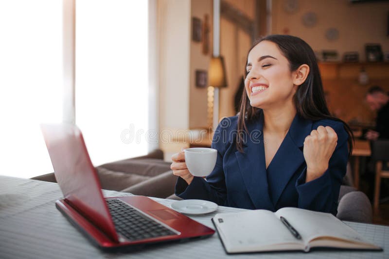 She is sitting at the table. Жизнерадостно на работе.