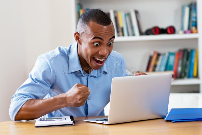 Cheering african american man at computer stock image