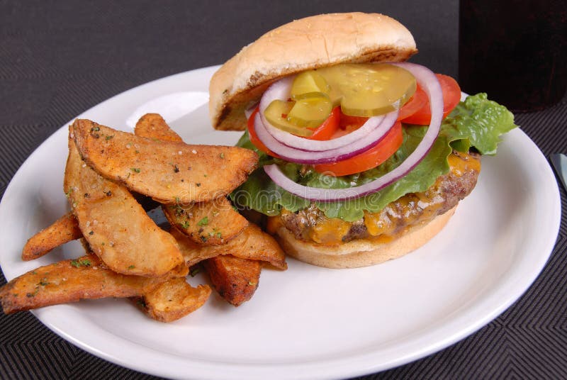 Cheese burger and fries with toppings royalty free stock photos