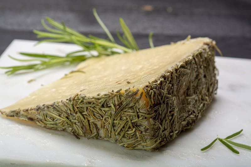 Cheese collection, one piece of Spanish manchego sheep cheese with rosemary herb