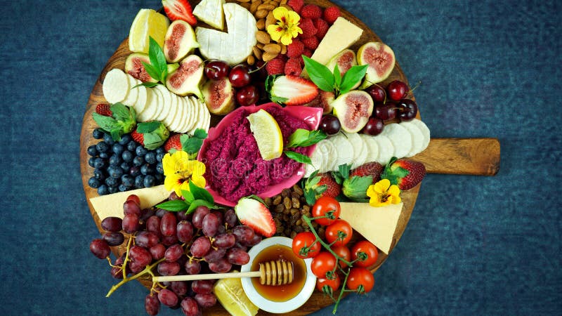 Cheese and fruit charcuterie dessert grazing platter on wooden board.