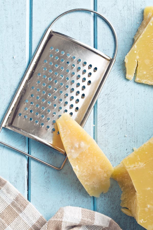 Cheese grater and parmesan stock image. Image of piece 49734233