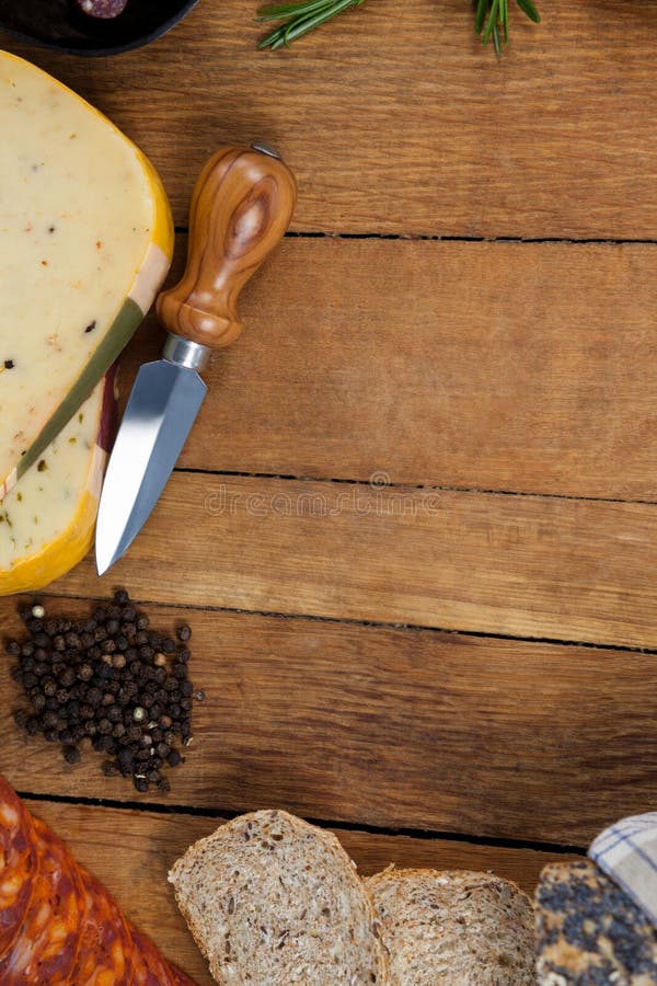 Cheese, Knife, Black Pepper and Bread on Chopping Board Stock Photo