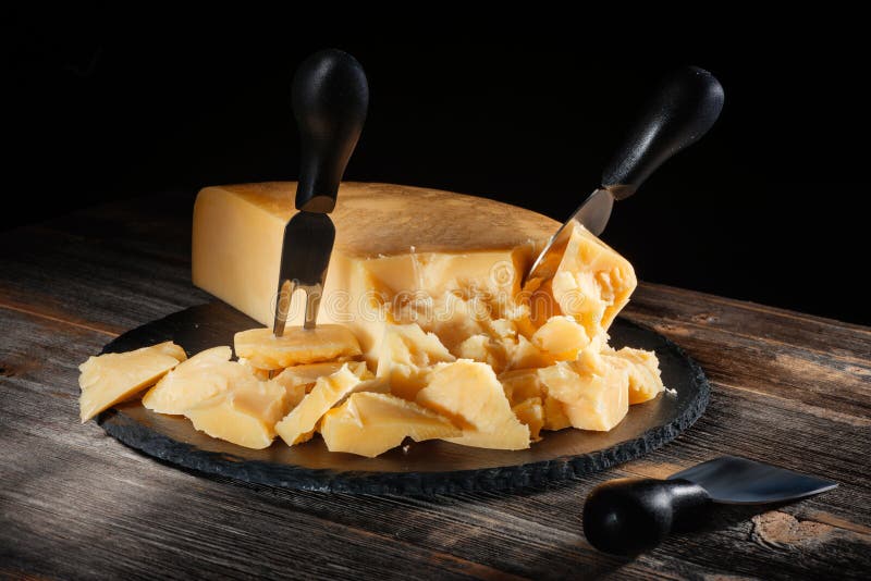 Cheese Parmesan with a Set of Knives on Round Slate Board in Style