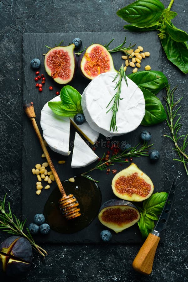 Cheese Plate. Brie Cheese, Fresh Figs and Honey on Stone Board. Space for Text Stock Photo