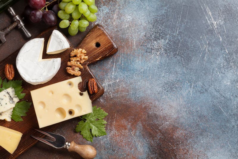 Cheese plate with grapes and nuts. Wine snaks. Top view with space for your text