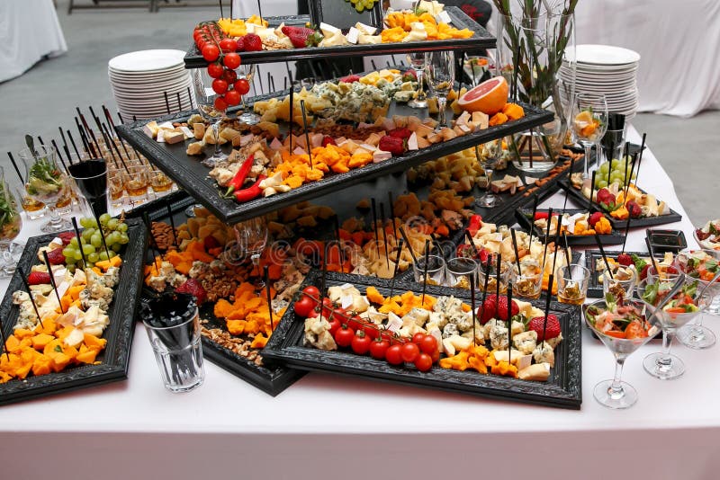 Cheese plate with variety of appetizers on table on event catering stock photos
