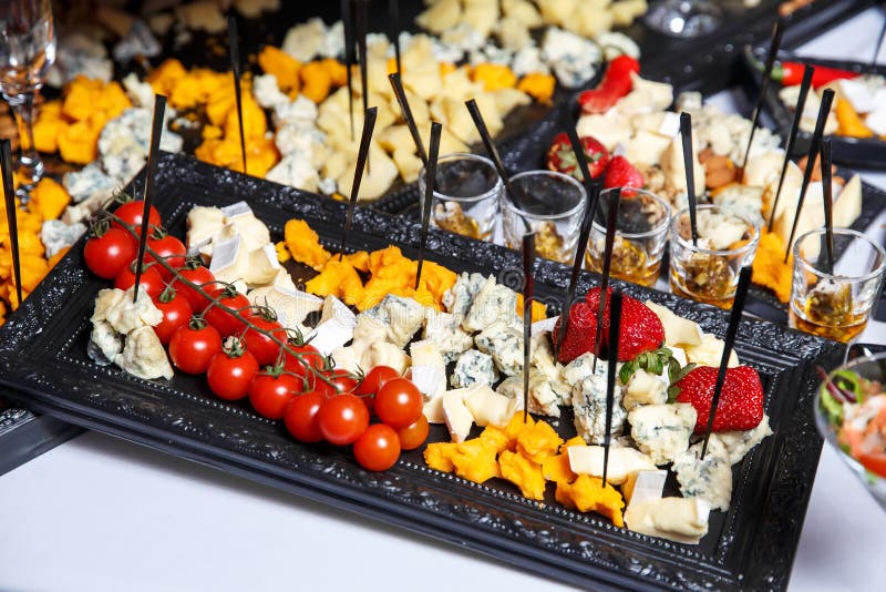 Cheese plate with variety of appetizers on table on event catering stock photo