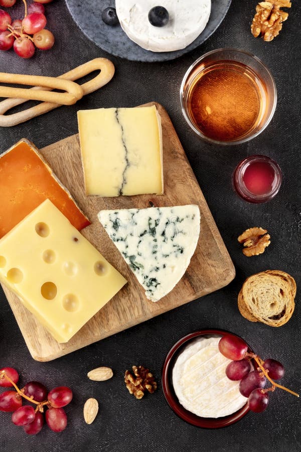 Cheese platter. Blue cheese, Brie, Emmental and others with wine, shot from the top. On a black background royalty free stock image Cheese platter. Blue cheese, Brie, Emmental and others with wine, shot from the top. On a black background royalty free stock image
