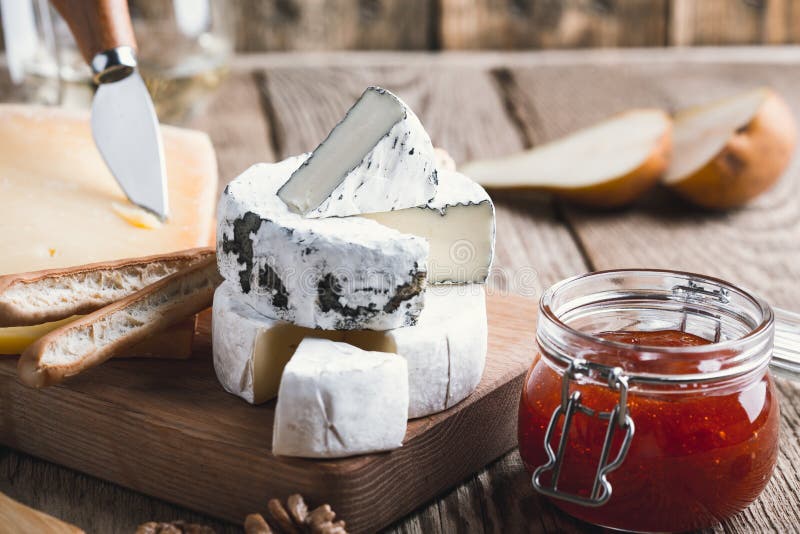 Cheese Platter with Wine, Jam and Walnuts on Wooden Board Stock Image