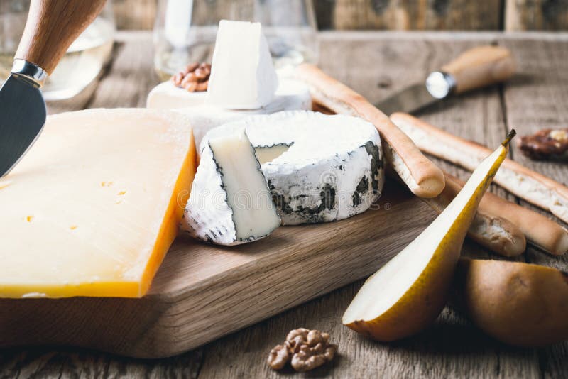 Cheese Platter with Wine, Jam and Walnuts on Wooden Board Stock Image