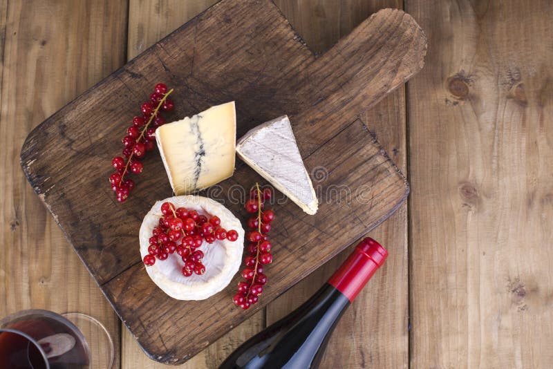 Cheese and red wine. Different cheese with white and blue mold. Berries of red currants White flowers. Wooden background and free royalty free stock photos Cheese and red wine. Different cheese with white and blue mold. Berries of red currants White flowers. Wooden background and free royalty free stock photos