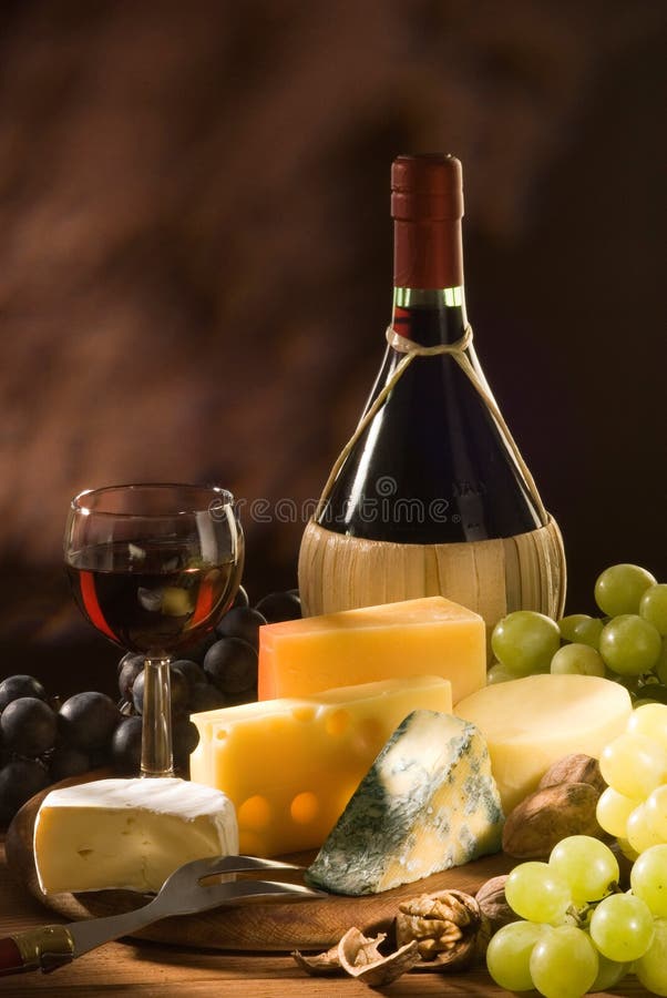 Glas und Flasche Rotwein, italienischer Weißwein mit verschiedenen Arten von Käse und Beilagen.