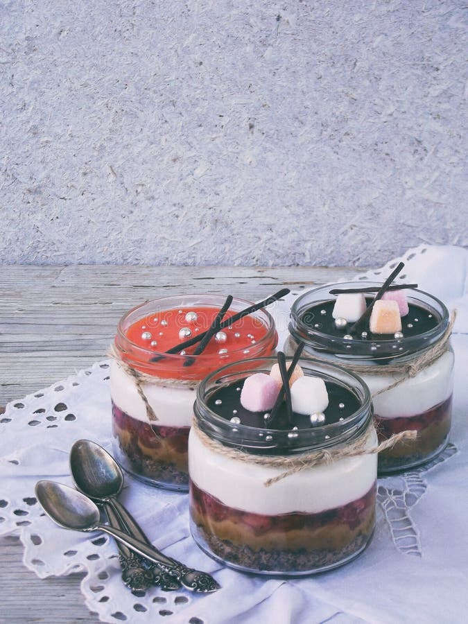 Cheesecake deser w szklanym słoju na drewnianym tle : czekoladowy ciastko, solony karmel, truskawki galareta, serowy mousse, choc zdjęcia stock Cheesecake deser w szklanym słoju na drewnianym tle : czekoladowy ciastko, solony karmel, truskawki galareta, serowy mousse, choc zdjęcia stock