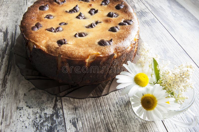 Cheesecake on an old table with a bouquet of camom