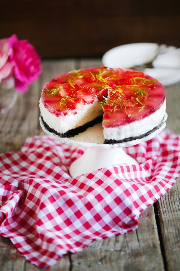 Cheesecake with strawberries in gelatine and herbs, on oreo cookies