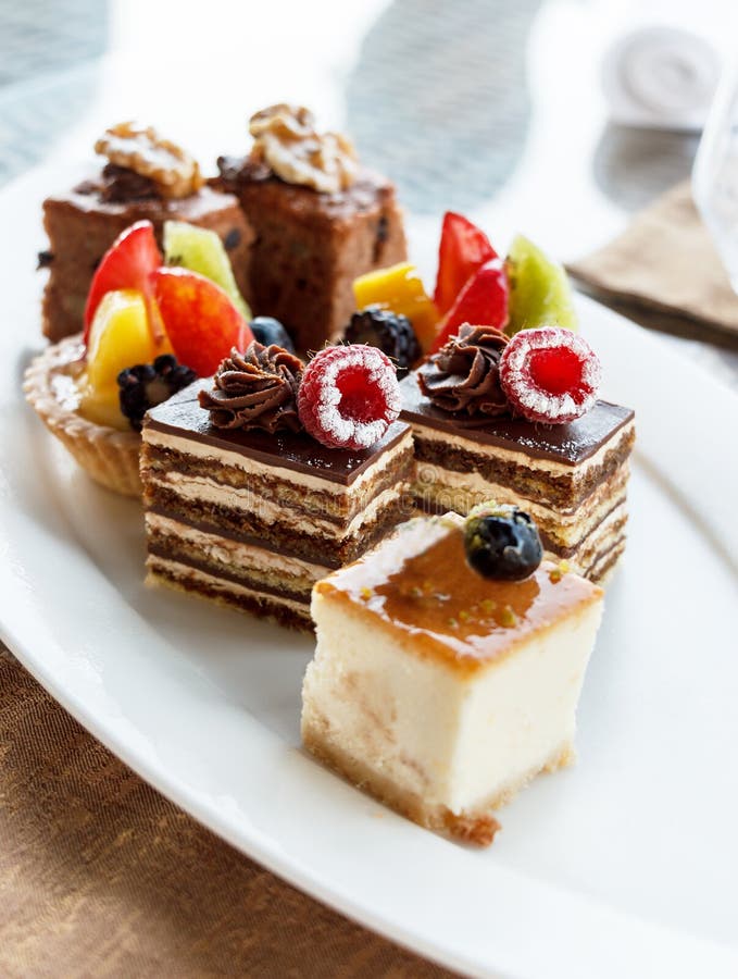 Cheesecake βανίλιας με το βακκίνιο Σύνολο μίνι κέικ στην κατάταξη στο άσπρο πιάτο καπνισμένος γάμος ντοματώ&nu Κέικ σοκολάτας με στοκ εικόνα Cheesecake βανίλιας με το βακκίνιο Σύνολο μίνι κέικ στην κατάταξη στο άσπρο πιάτο καπνισμένος γάμος ντοματώ&nu Κέικ σοκολάτας με στοκ εικόνα