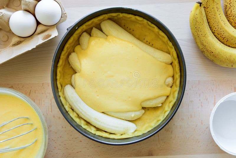 Cheesecake κέικ μπανανών προετοιμασιών που κάνει από τα συστατικά στο ξύλινο επιτραπέζιο υπόβαθρο Επίπεδος βάλτε Τοπ όψη στοκ εικόνα Cheesecake κέικ μπανανών προετοιμασιών που κάνει από τα συστατικά στο ξύλινο επιτραπέζιο υπόβαθρο Επίπεδος βάλτε Τοπ όψη στοκ εικόνα