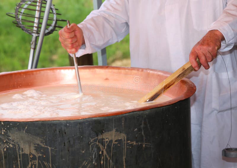 Cheesemaker sprawdza temperaturę wrzący mleko w po fotografia royalty free Cheesemaker sprawdza temperaturę wrzący mleko w po fotografia royalty free