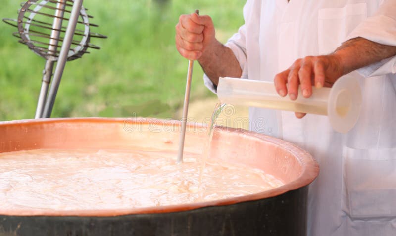 Cheesemaker χύνει rennet γάλακτος στο δοχείο χαλκού για την κατασκευή του τυριού στοκ φωτογραφία με δικαίωμα ελεύθερης χρήσης Cheesemaker χύνει rennet γάλακτος στο δοχείο χαλκού για την κατασκευή του τυριού στοκ φωτογραφία με δικαίωμα ελεύθερης χρήσης