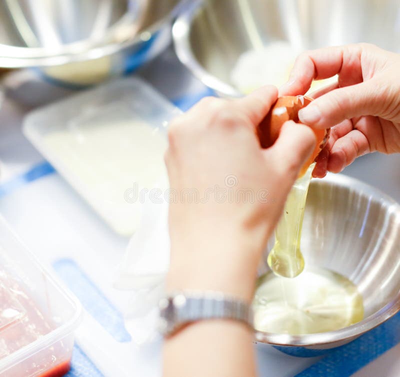 Chef Breaks the Egg into a Glass Bowl, Separating the Yolk from the Egg