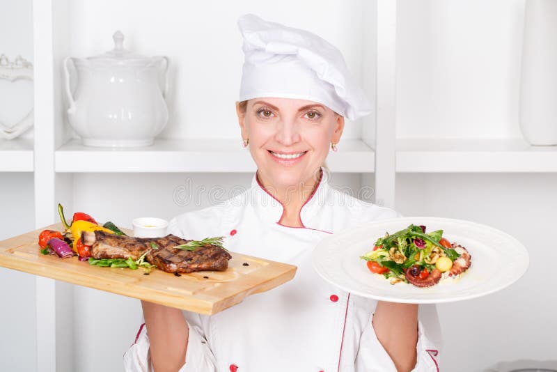 Cooking or present. Женщина повар держит в руках разделочную доску. Представляет еду.