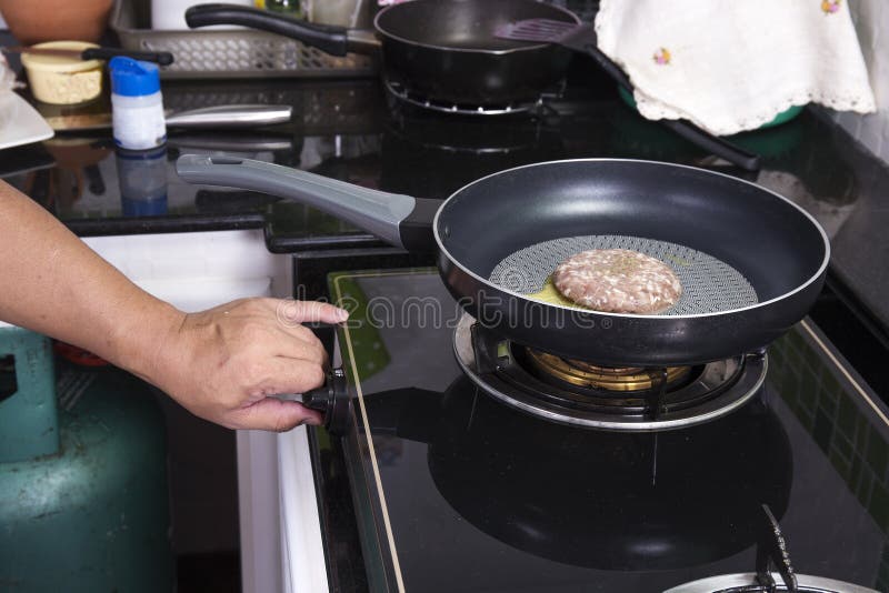 Chef cooking beef Burger in the pan stock image