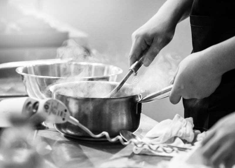 Chef Cooking in a Kitchen, Chef at Work, Black & White Stock Image