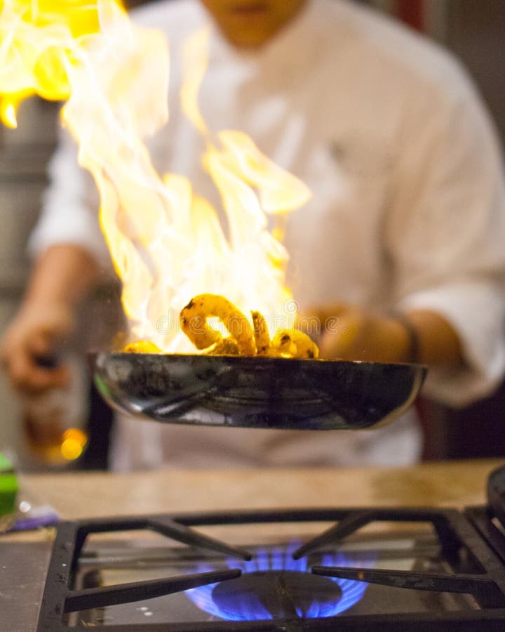 Chef cooking. A chef cooking in the kitchen with flaming gas fire Chef cooking. A chef cooking in the kitchen with flaming gas fire