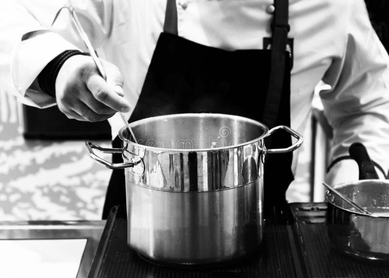 Chef Cooking in a Kitchen, Chef at Work, Black & White Background Stock