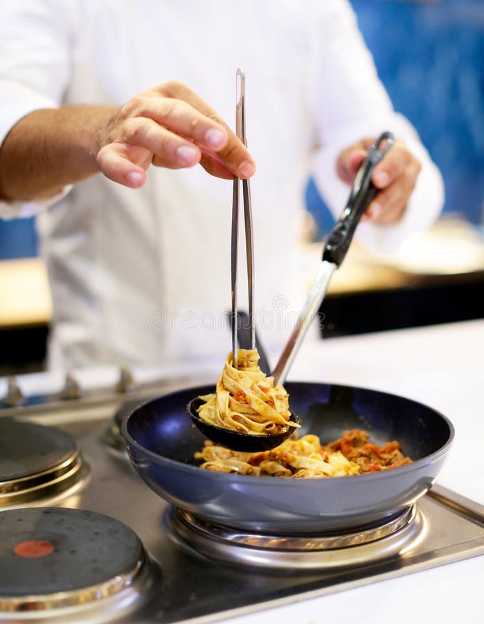 Chef Cooking Pasta, Chef Serves Spaghetti Carbonara on the Plate in the Kitchen Stock Photo