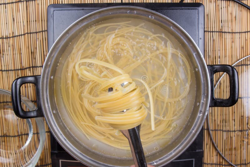 Chef cooking spaghetti in the pan