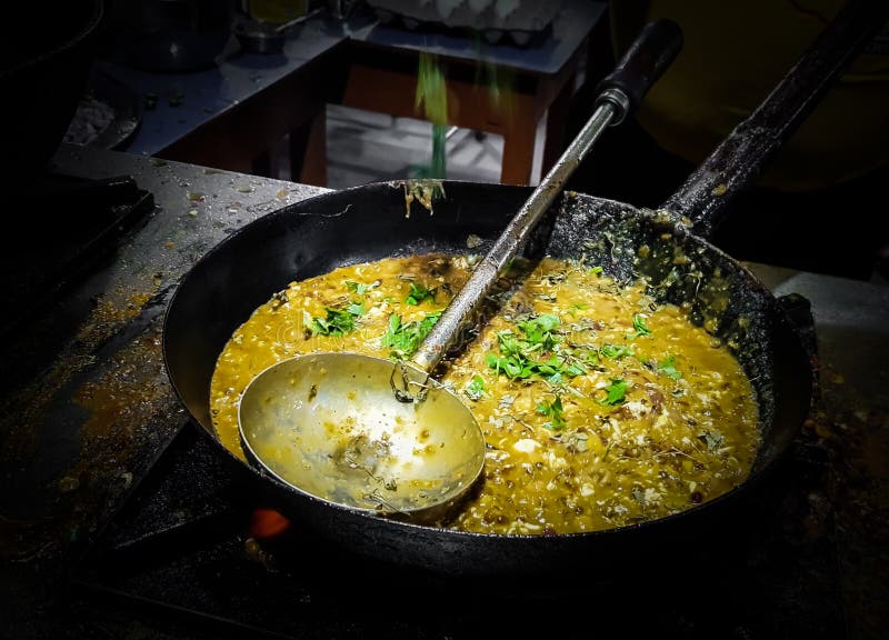 A chef cooking tadka fry in a frying pan at a road side food corner on a stove over flames royalty free stock images A chef cooking tadka fry in a frying pan at a road side food corner on a stove over flames royalty free stock images