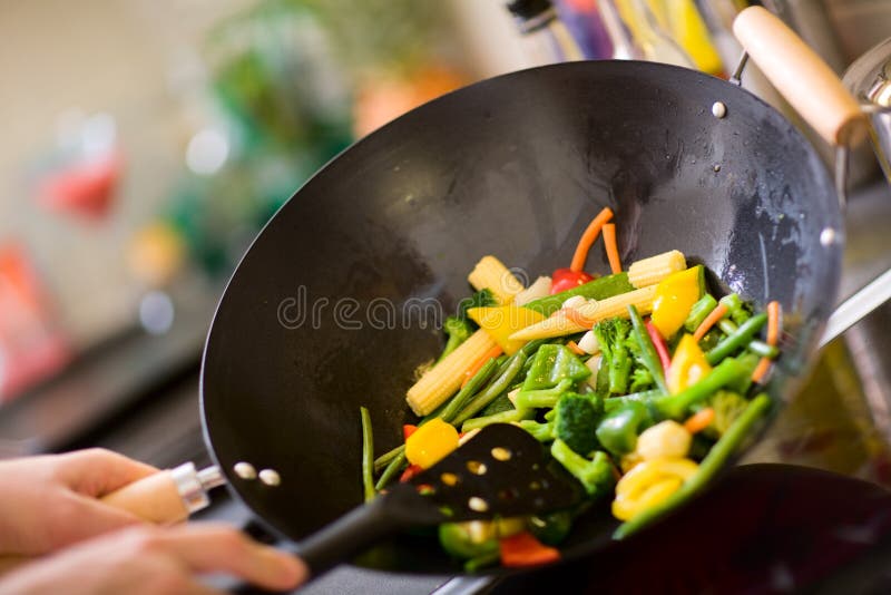 Chef cooking wok. Chef cooking vegetables in wok pan royalty free stock photo