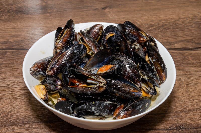 The Chef Cooks Mussels in a Shell in Blue Cheese Sauce Stock Photo