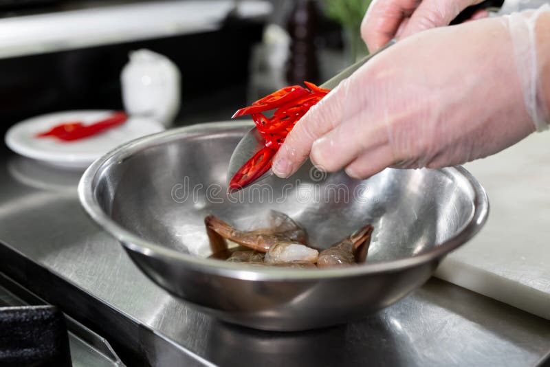 Chef Cuts Hot Chili Peppers in the Kitchen. Stock Photo Image of