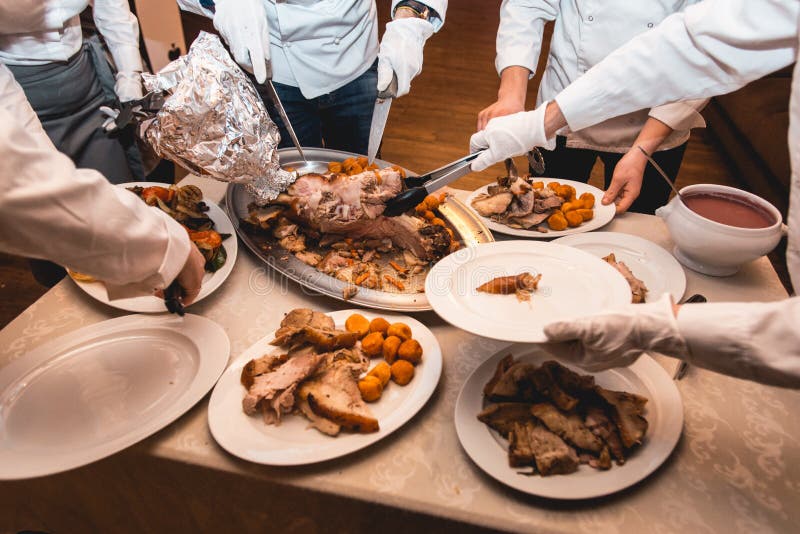 Chef cuts roasted meat for restaurant guests