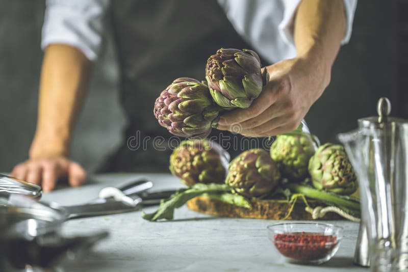 Chef Cutting Artichokes for Dinner Preparation Man Cooking Inside