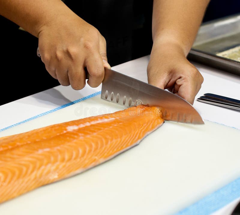 Chef Cutting Fresh Salmon Fillet in Kitchen, Chef Cuts the Salmon .Chef