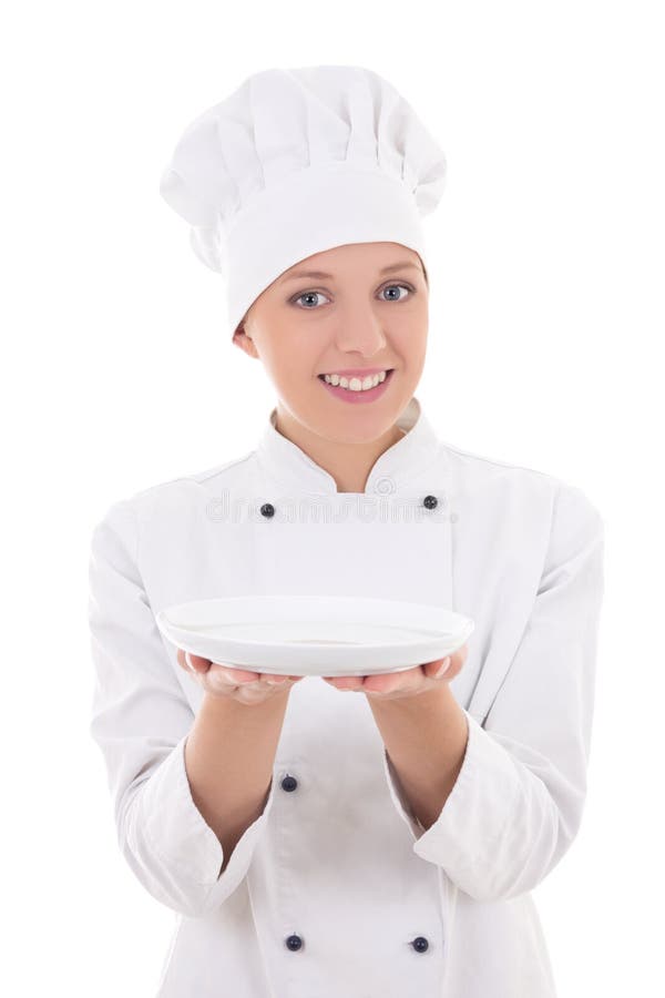 Chef de jeune femme dans l'uniforme montrant le plat vide d'isolement sur le whi photos stock Chef de jeune femme dans l'uniforme montrant le plat vide d'isolement sur le whi photos stock