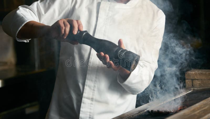 Chef, der Rindfleischsteak auf bbq in der Restaurantküche kocht stockfotos Chef, der Rindfleischsteak auf bbq in der Restaurantküche kocht stockfotos