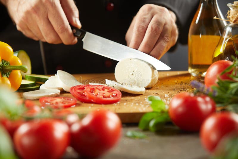 Chef, der traditionellen Italiener Caprese-Salat macht lizenzfreie stockfotografie Chef, der traditionellen Italiener Caprese-Salat macht lizenzfreie stockfotografie