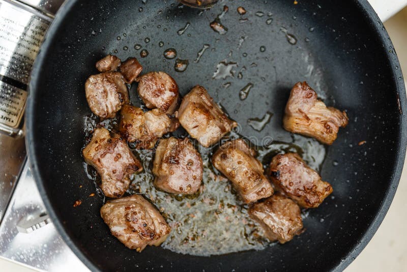 Chef Fried Marinated Diced Raw Beef in Pan Mit Rosemary Oil Stockbild Bild von rindfleisch