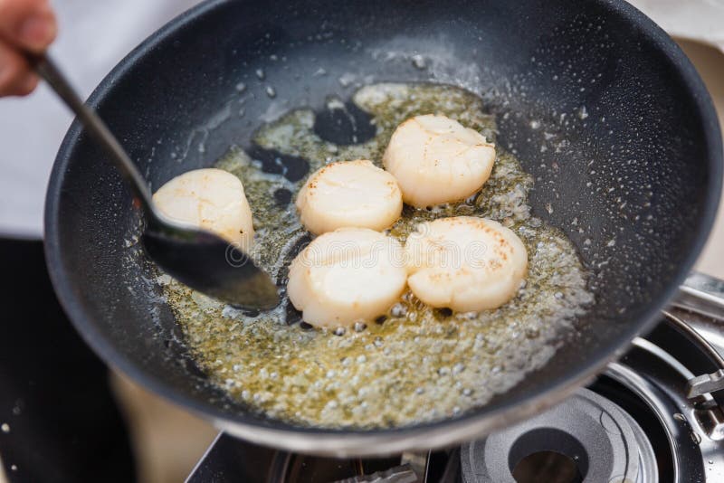 Chef Fried Scallops with Rosemary Oil in Pan with Spoon Stock Photo