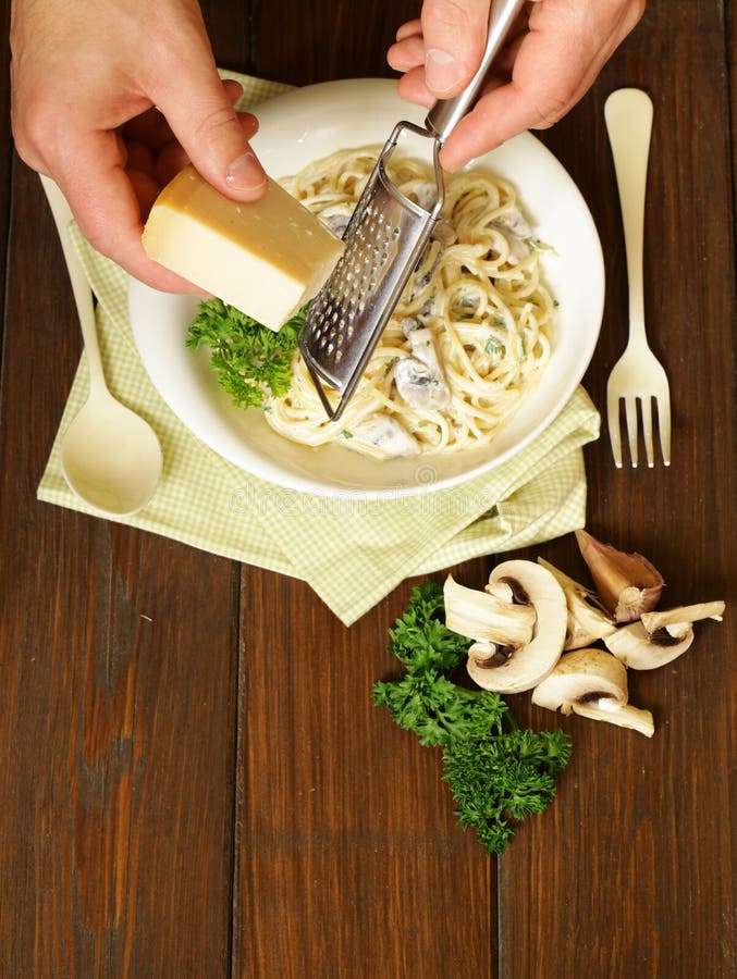 Chef grate parmesan cheese on pasta carbonara