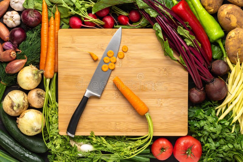 Fresh vegetables on woden cutting board with knife