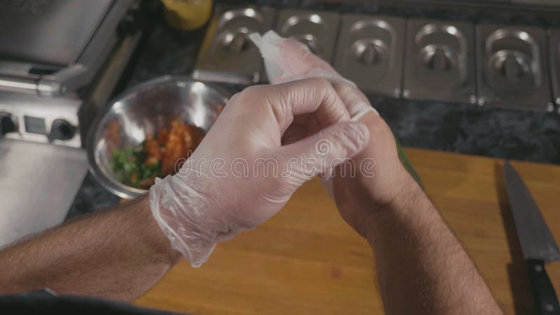 Chef-kok die voor kokvoedsel voorbereidingen treffen in restaurant, hij die de latexhandschoenen zetten
