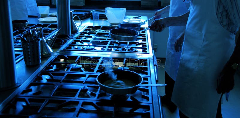 Chef-koks die met pannen werken stock foto Chef-koks die met pannen werken stock foto