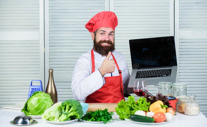 Chef laptop read culinary recipes. Culinary school. Hipster in hat and apron learning how to cook online. Culinary stock photo Chef laptop read culinary recipes. Culinary school. Hipster in hat and apron learning how to cook online. Culinary stock photo